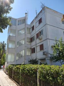 a white building with a fence in front of it at Apartment ,,The Mall Athens" in Athens