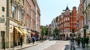 um grupo de pessoas andando por uma rua da cidade com edifícios em Central 2Bed Mew in Marylebone em Londres