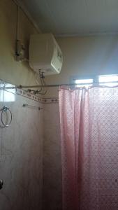 a bathroom with a shower curtain and a air conditioner at Afecto in San Gregorio de Polanco