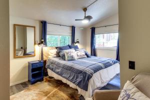 een slaapkamer met een bed met blauwe lakens en een spiegel bij Peaceful Pinetop Hideaway with Yard - Dog Friendly! in Pinetop-Lakeside