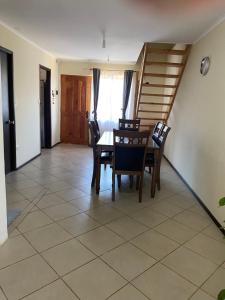 a dining room with a table and chairs and a staircase at Casa Parque Rauquen in Curicó