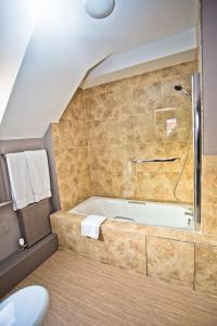 a bathroom with a bath tub and a shower at Wards Hotel & Restaurant in Folkestone