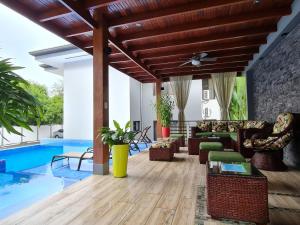 sala de estar con techo de madera y piscina en Ballena Paradise Condos, en Uvita