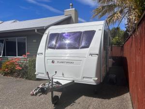 een witte camper geparkeerd voor een huis bij Kiwi Caravan Experience in Motueka