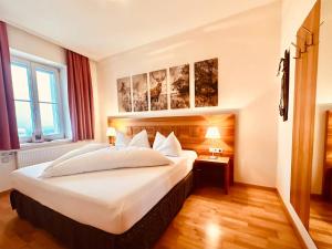 a hotel room with a large bed and a window at TirolerHof Dölsach in Lienz