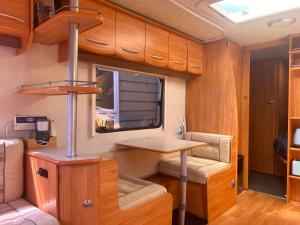 Kiwi Caravan Experience في موتويكا: غرفة صغيرة مع طاولة في مقطورة