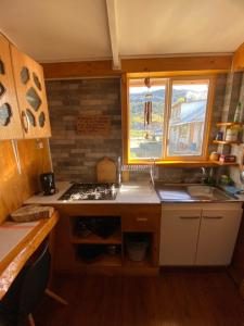 a kitchen with a sink and a stove and a window at Los alamos in Puerto Tranquilo