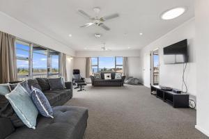 ein Wohnzimmer mit einem Sofa und einem Flachbild-TV in der Unterkunft Woodward House Taupo in Taupo