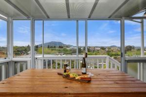 a table with a bottle of wine and a plate of food at Woodward House Taupo in Taupo