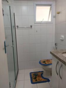 ein Bad mit einer Dusche, einem WC und einem Fenster in der Unterkunft Diamante in Guarapari