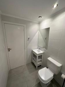 La salle de bains est pourvue de toilettes, d'un lavabo et d'un miroir. dans l'établissement Mar y Cielo, à Necochea