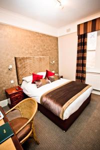a bedroom with a large bed with red pillows at Wards Hotel & Restaurant in Folkestone