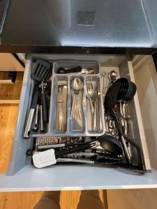 a drawer full of utensils in a box at Cozy Modern Apartment in Croydon Central in Croydon