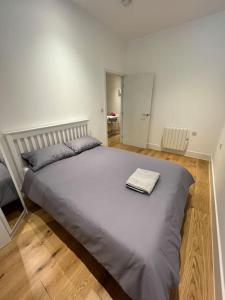 ein Schlafzimmer mit einem großen Bett und einem Handtuch darauf in der Unterkunft Cozy Modern Apartment in Croydon Central in Croydon