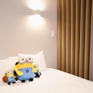 two stuffed animals are sitting on a bed at Koti Sopo Universal Bay 2 by Liaison in Osaka