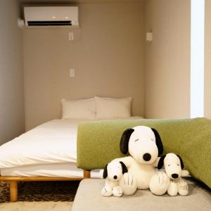 three stuffed animals sitting on the floor next to a bed at Koti Sopo Universal Bay 2 by Liaison in Osaka