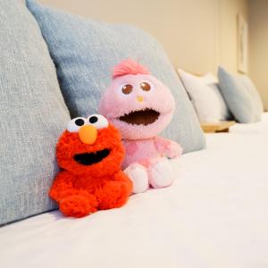 two stuffed animals are sitting on a bed at Koti Sopo Universal Bay 4 by Liaison in Osaka