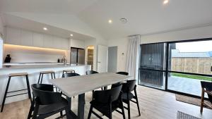 a kitchen and dining room with a table and chairs at Remarkable Stay with Mountain View’s in Frankton Wharf