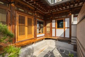 首爾的住宿－Luxury hanok with private bathtub - SN06，拥有木门和窗户的房屋入口