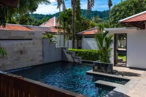 a swimming pool in the backyard of a house at Luxurious Residence Rawai in Phuket Town