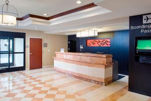 a lobby with a reception desk and a sign that readsboarding pass at Courtyard Palo Alto Los Altos in Palo Alto