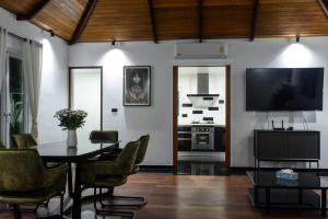 a living room with a table and a tv at Luxurious Residence Rawai in Phuket Town