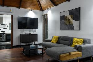 a living room with a couch and a tv at Luxurious Residence Rawai in Phuket Town