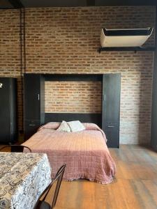 1 dormitorio con cama y pared de ladrillo en Loft luminoso en Capital Federal en Buenos Aires