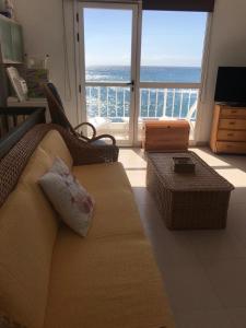sala de estar con sofá y vistas al océano en VV YELYMAR. PLAYA DE ALOJERA en Alojera