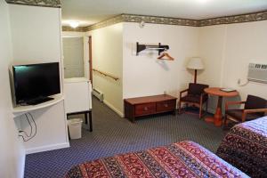 a hotel room with two beds and a flat screen tv at Potsdam Inn in Potsdam