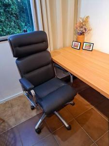 una sedia nera seduta accanto a una scrivania di legno di Studio 109-comfortable, practical, great location a Brasilia