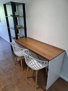 a wooden table with two chairs and a shelf at Studio 109-comfortable, practical, great location in Brasilia