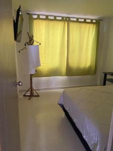 a bedroom with a bed and a window with a lamp at Tunja Magic Habitación. in Tunja