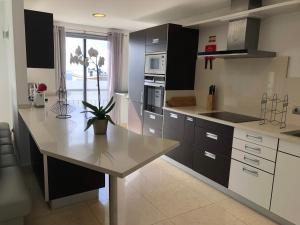 une cuisine avec un comptoir blanc et une table dans l'établissement Forum Ocean View Apartment, à Funchal