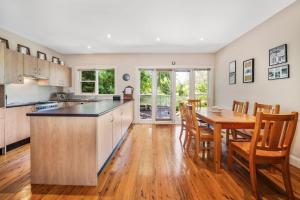 a kitchen and dining room with a table and chairs at Brigalow Cottage in Leura