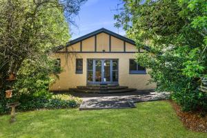 a house with a yard with a grass yard at Brigalow Cottage in Leura