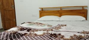 Una cama con un edredón encima. en Honey hut. en Anachal