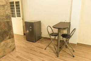 a table and two chairs next to a small refrigerator at Oasis Maya in Tuxtla Gutiérrez