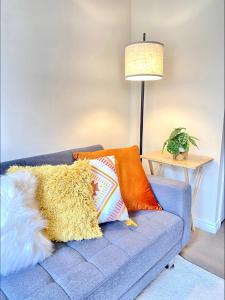 a blue couch with pillows on it in a living room at Oakley Vale House and Garden! Free Private Parking, TV, Fully Equipped in Corby +26 photos