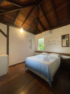a bedroom with a bed and a wall with writing on the wall at Pousada Kaimana - Maresias in Maresias