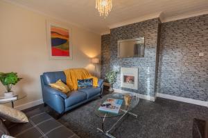 sala de estar con sofá azul y pared de ladrillo en OG Tranquil Stays- Free WiFi, Office, Free secured parking and garden, en Thornaby on Tees
