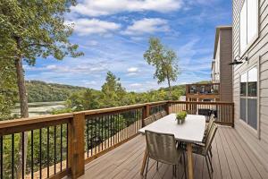 una terrazza in legno con tavolo e sedie. di Gorgeous Lake Cabin Hot Tub a Branson