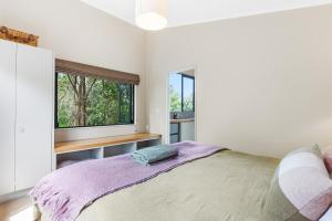 Un dormitorio con una cama grande y una ventana en Winemakers Loft, en Oneroa