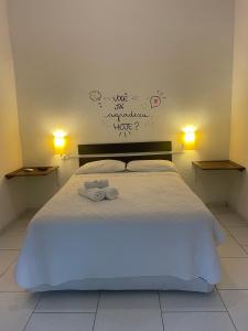 um quarto com uma cama com duas toalhas em Pousada Kaimana - Maresias em Maresias