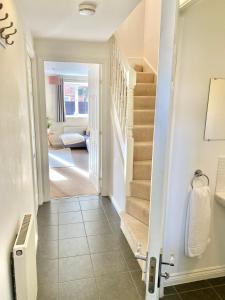 a hallway with stairs leading to a living room at Oakley House - Spacious 3 Bedroom, Garden and Parking in Corby