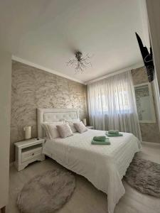 ein Schlafzimmer mit einem weißen Bett und einem Kronleuchter in der Unterkunft Family friendly house with a swimming pool Sibenik - 21484 in Šibenik