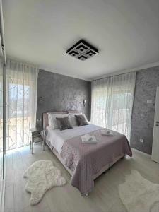 ein Schlafzimmer mit einem großen Bett und einigen Fenstern in der Unterkunft Family friendly house with a swimming pool Sibenik - 21484 in Šibenik