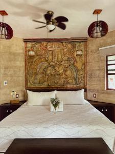 - une chambre avec un grand lit orné d'une peinture murale dans l'établissement Hotel Boutique Aurea, à Bacalar