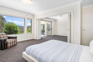 a bedroom with a bed and a large window at Cliffnest House & Studio in Katoomba