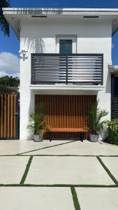 een wit huis met een houten bank ervoor bij Luna y Sol Calle 8 in Miami